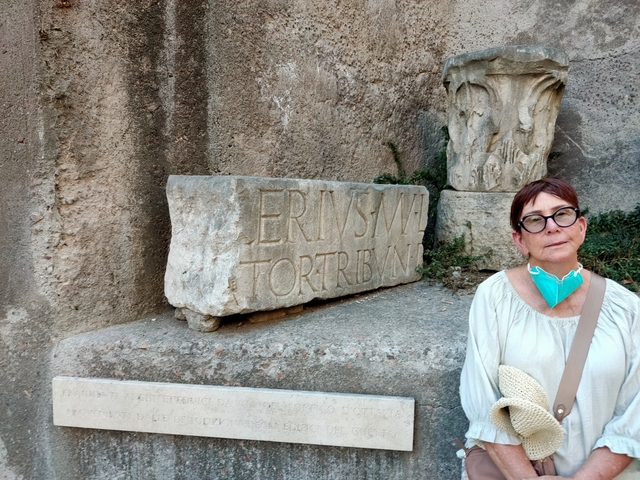       Person standing next to an engraved stone slab
  
