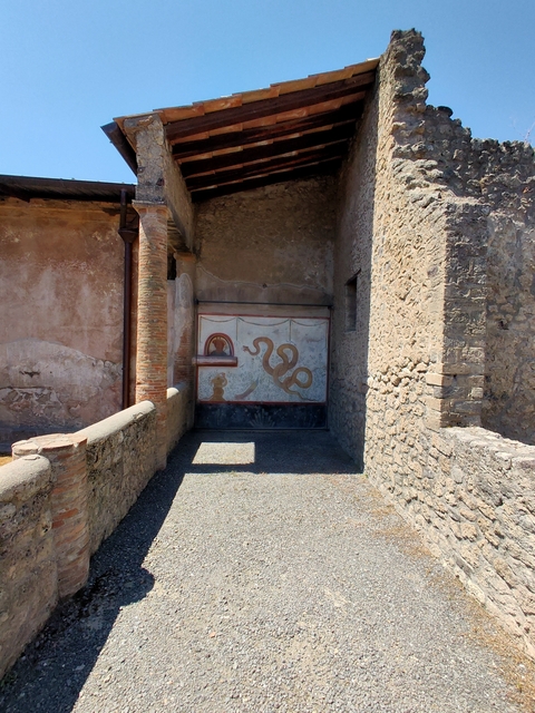       Ancient mural on a stone wall with a snake design
  