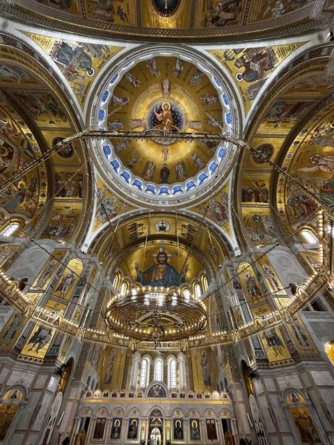       Interior of a church with ornate golden decor and paintings.
  