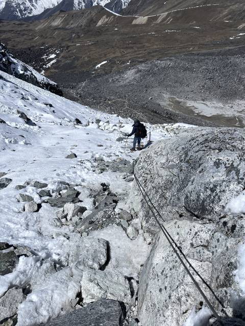 Person climbing on a rocky, snowy slope.
