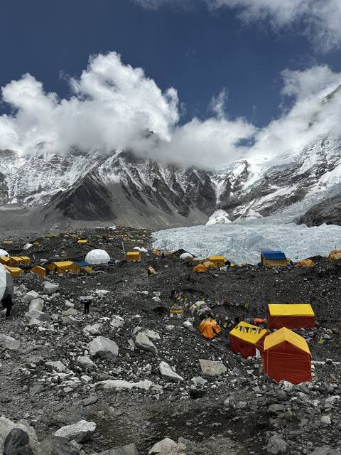 Base camp area with colorful tents under a mountain