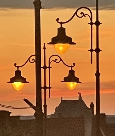 Street lamps silhouetted against a sunset sky.