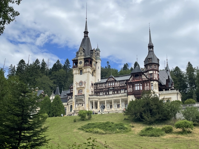 A grand castle surrounded by lush greenery.