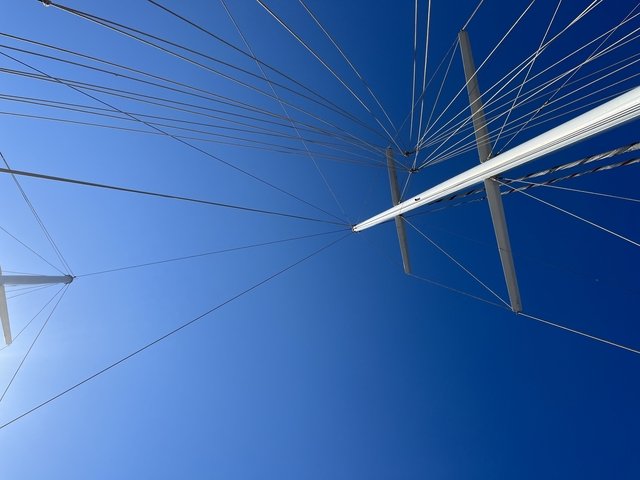 Looking upward at sailboat masts and blue sky
