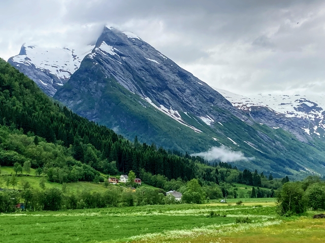       A rural landscape with a sharp mountain ridge.
  