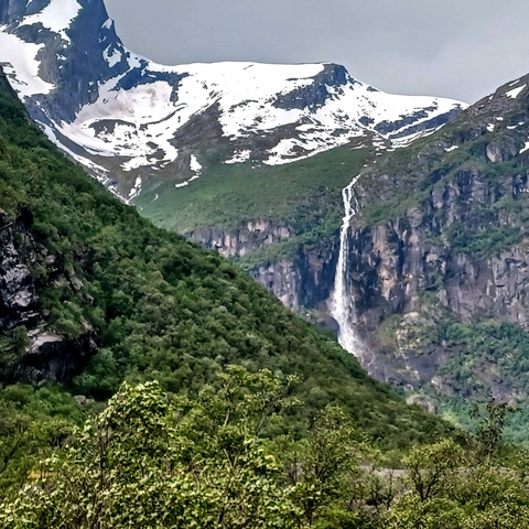       A distant waterfall cascading down a mountain.
  