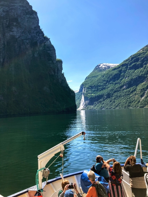 A fjord with steep cliffs and a waterfall.