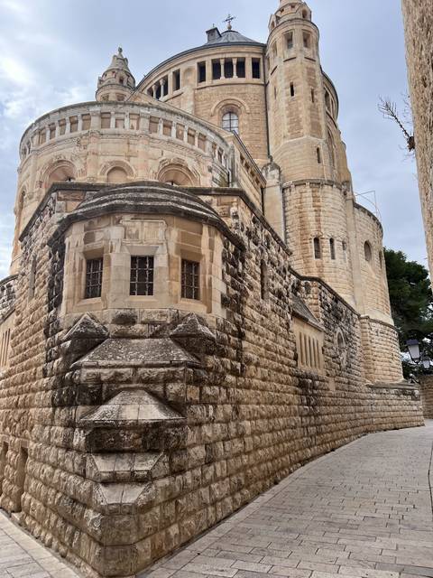      Stone building with ornate architecture and a large dome.
  