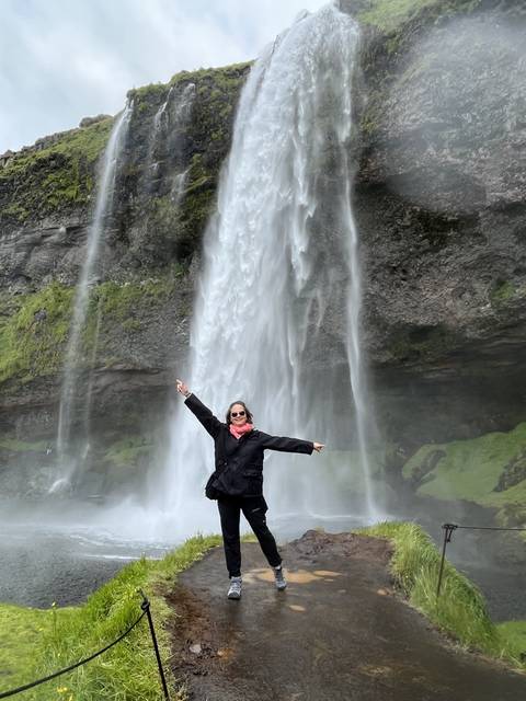       Person posing with a waterfall in the background.
  