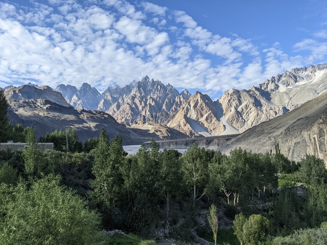       Mountain peaks with vibrant greenery and clear blue skies.
  