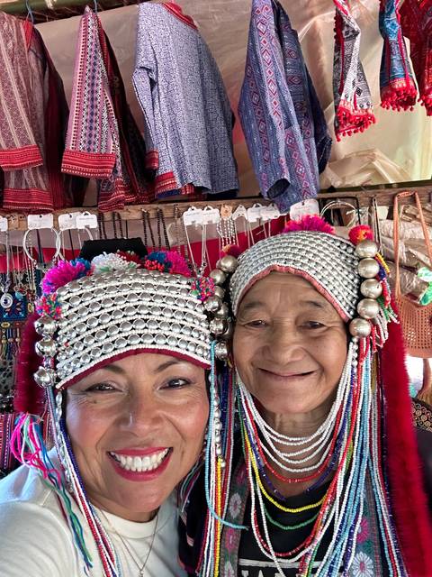       Two people in traditional costumes smiling.
  