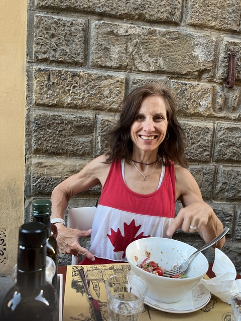       Woman smiling and at a café table.
  