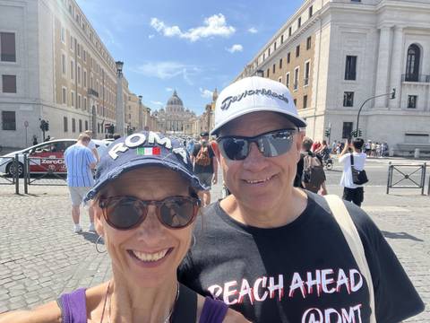       Couple posing on a busy street with a cityscape in the background.
  