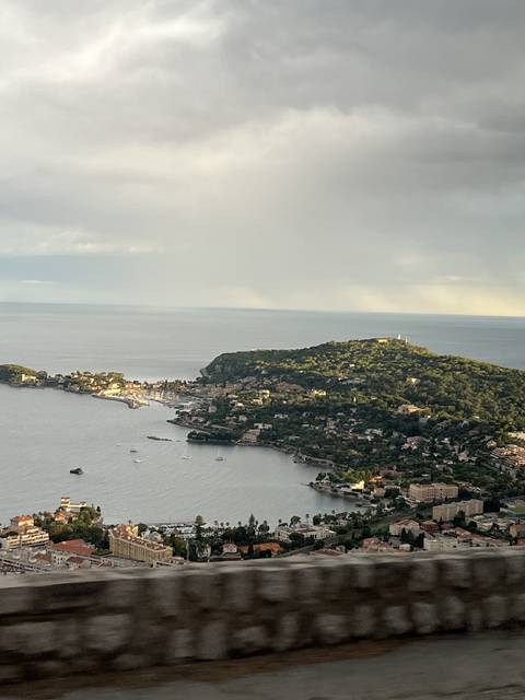 Coastal town with the sea and surrounding hills.