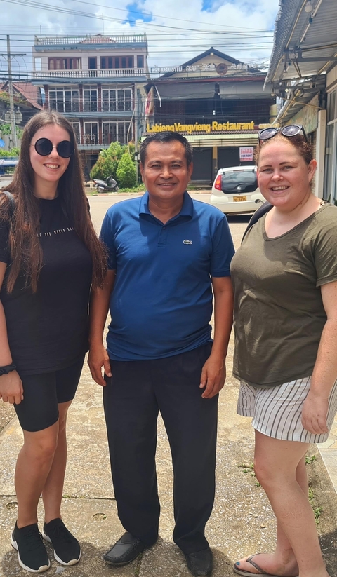       Three people standing together posing for a photo.
  
