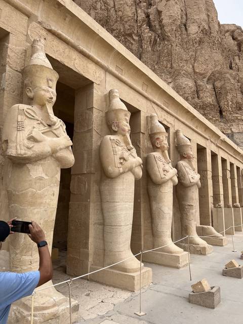       Row of Egyptian statues at an ancient site.
  