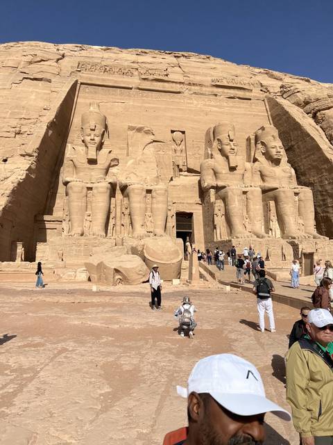       Massive statues of seated figures at temple entrance.
  