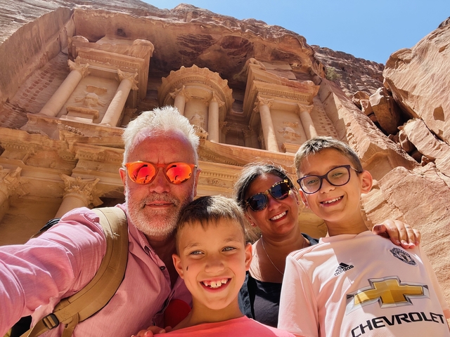 A family taking a selfie in front of Petra.