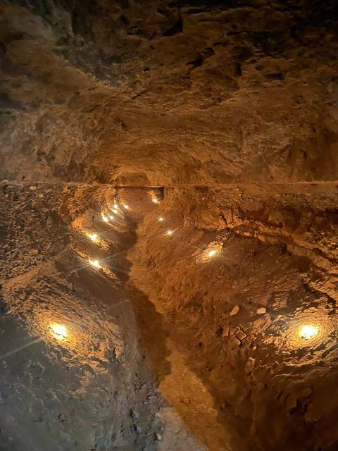 Interior cave walkway with artificial lighting.