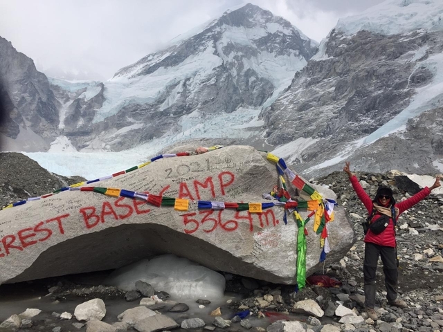 Person standing beside a rock that says Everest Base Camp