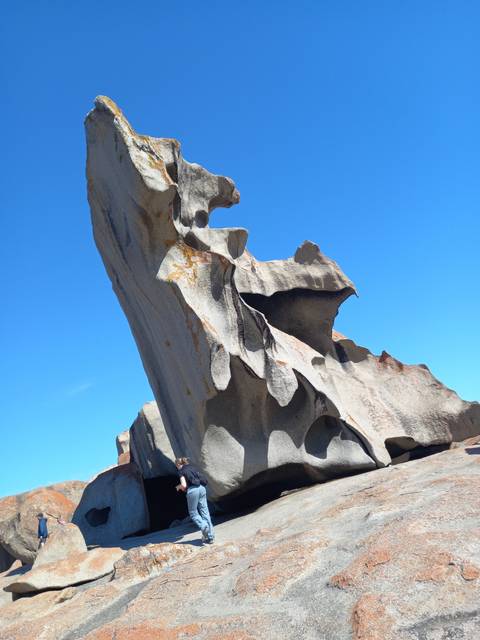 Person standing under the Remarkable Rocks formation.