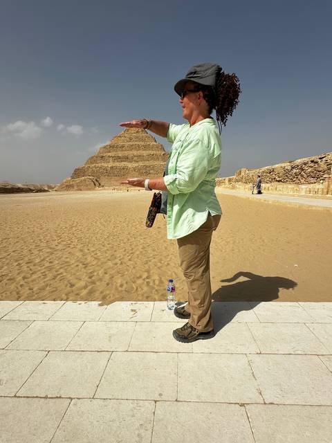 Tourist posing with pyramids.