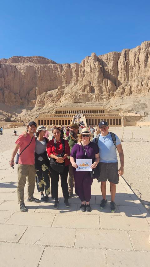 Group of tourists posing in front of an ancient temple.