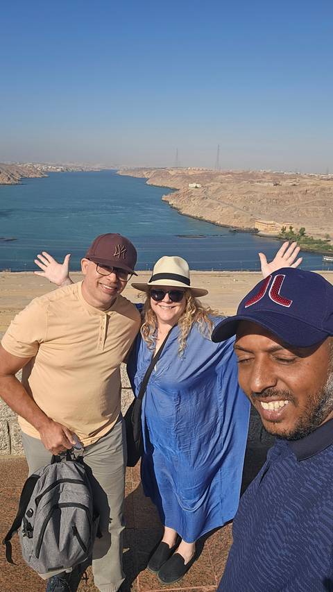       Three people taking a selfie with a river view.
  