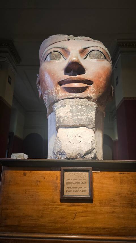       A large ancient statue on display indoors.
  