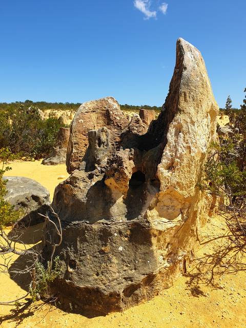      Unique rock formation under a clear blue sky.
  