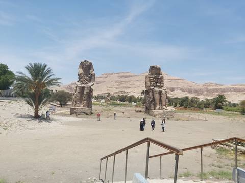 The Colossi of Memnon statues in a desert landscape.