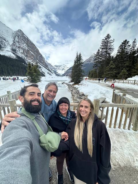       Family taking a selfie in a snowy mountainous area.
  