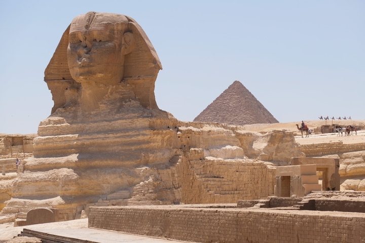 The Great Sphinx of Giza with a pyramid in the background.