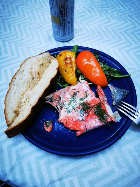 Plate of salmon with vegetables and bread.