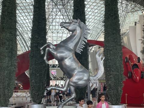 Upside-down image of a metallic horse statue indoors.