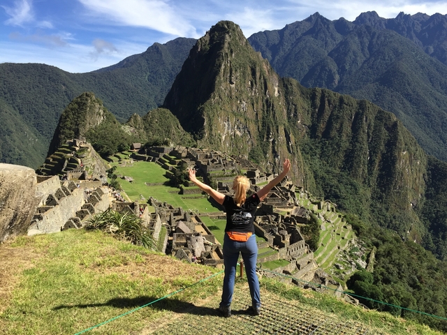       Person celebrating with arms raised overlooking Machu Picchu
  