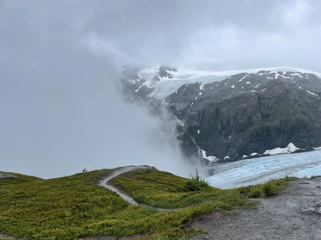       Foggy mountain landscape with a glacier.
  