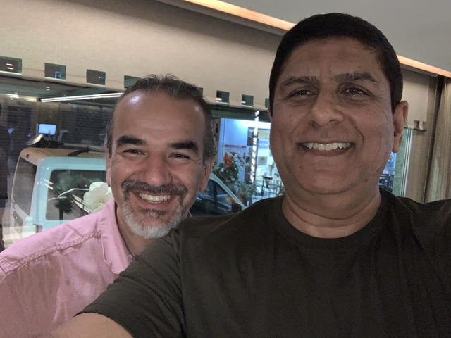       Two men smiling for a selfie indoors.
  