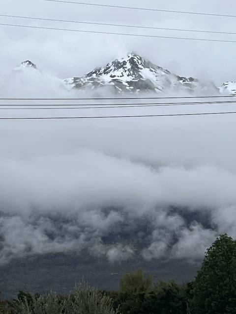       Snow-capped mountains and clouds visible in the background.
  
