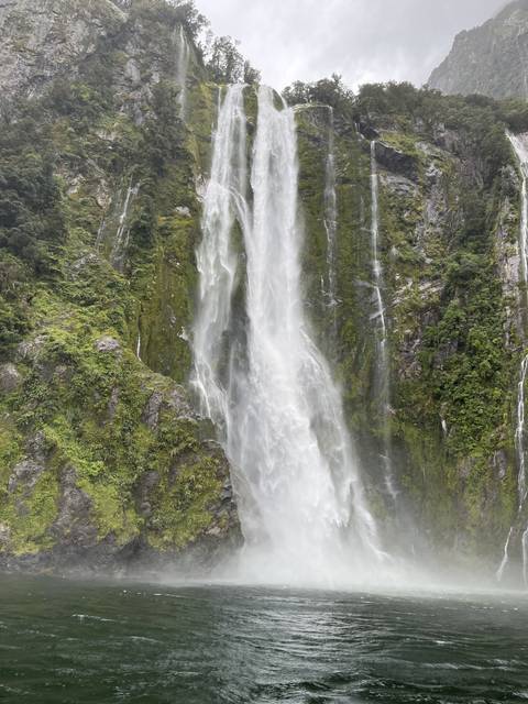       Waterfalls cascading down a lush green cliffside.
  
