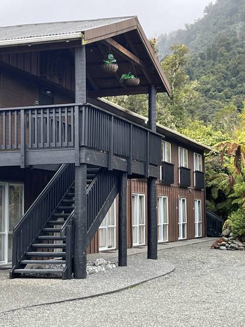       A wooden multi-story building in a forested area.
  