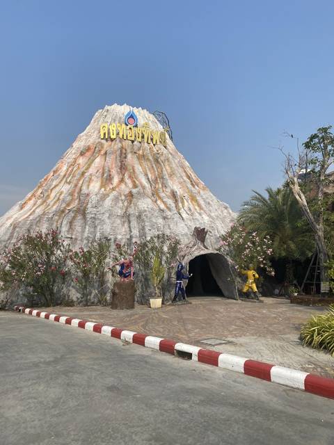 A theme park entrance with statues and a cave-like facade.