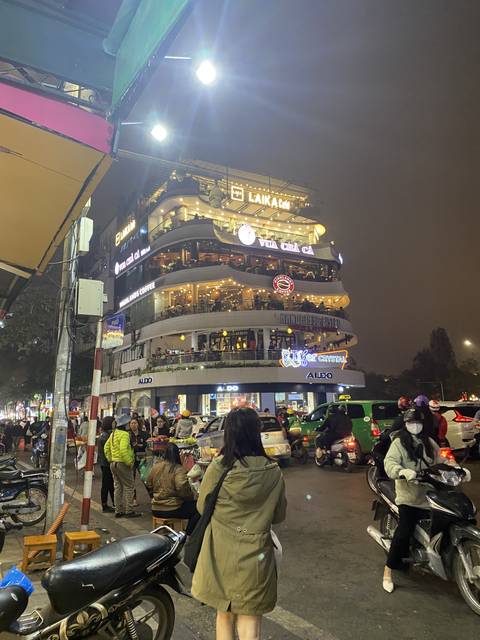 A busy street at night with illuminated modern buildings.