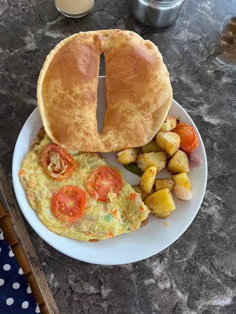       Plate with omelette, bread, and roasted potatoes.
  