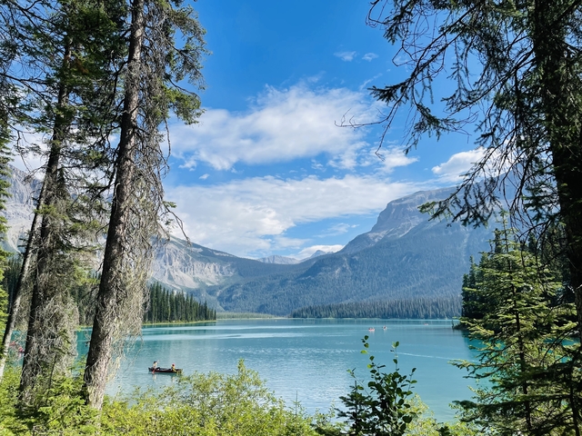       Serene lake surrounded by dense forest and mountains.
  