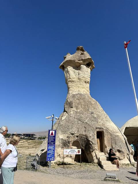       Person beside a tall rock formation.
  