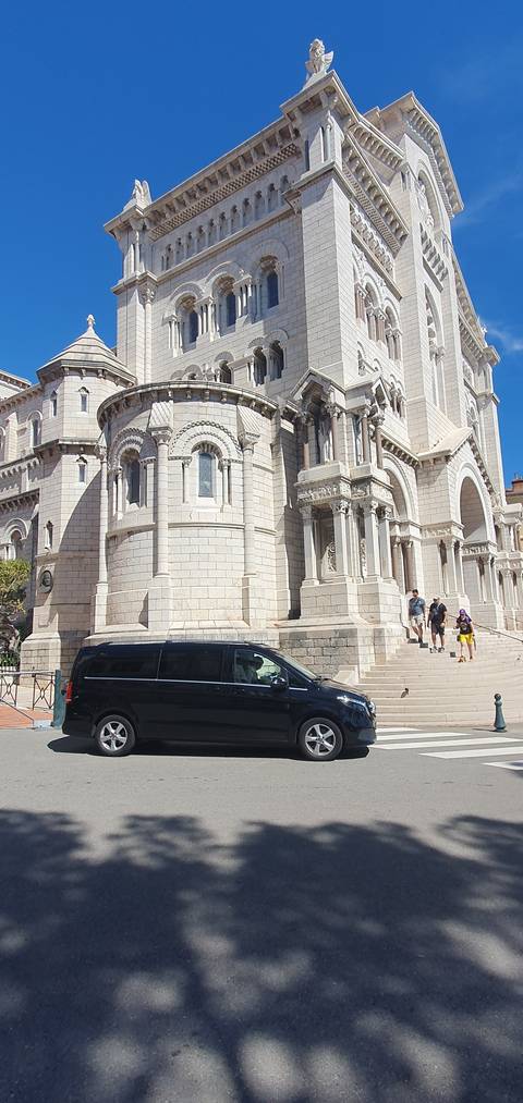      Large cathedral with people walking by.
  