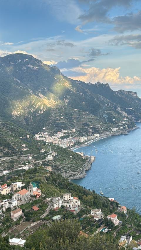 Aerial view of a coastal area with mountains and sea.
