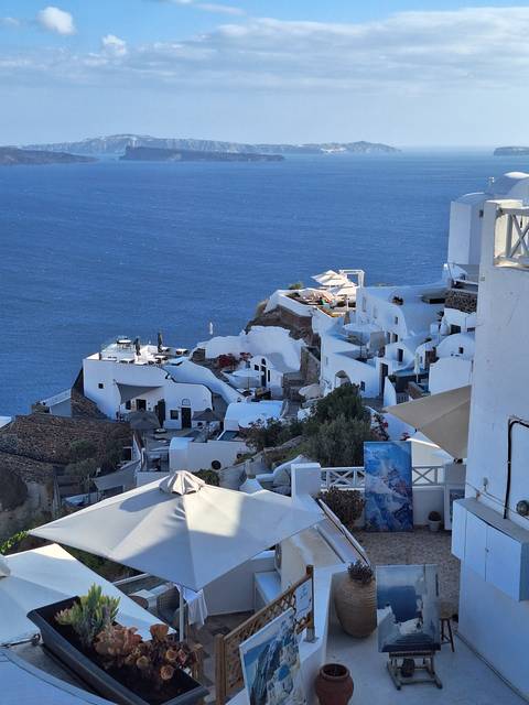       View of white buildings on a cliff overlooking the sea.
  