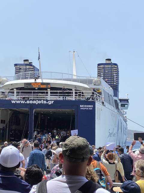       People boarding a ferry with visible text and logo.
  